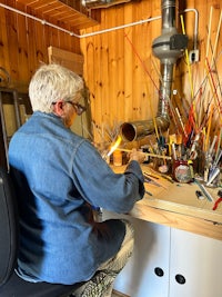 a woman working in a workshop with a lot of tools