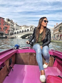 a woman sitting on a pink boat in venice